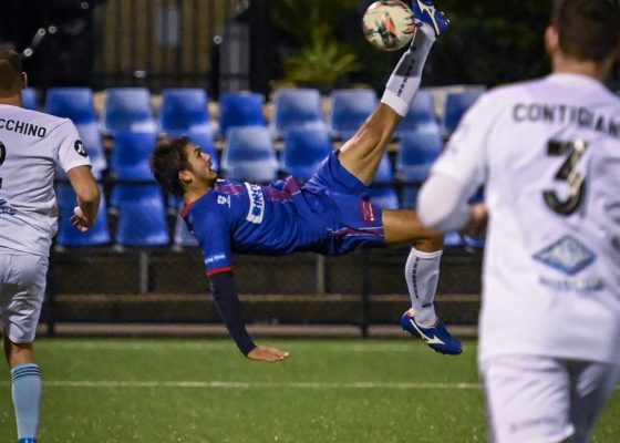 Bruno Mendes scores with a bicycle kick during the Round 14 NPL NSW Men's game between Manly United and Sutherland Sharks in 2022. Photo credit: Jeremy Denham