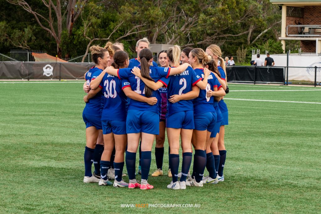 Manly United huddle before their NPL NSW Women's Round 3 game against Gladesville Ravens at Christie Park. Photo credit: Jeremy Denham