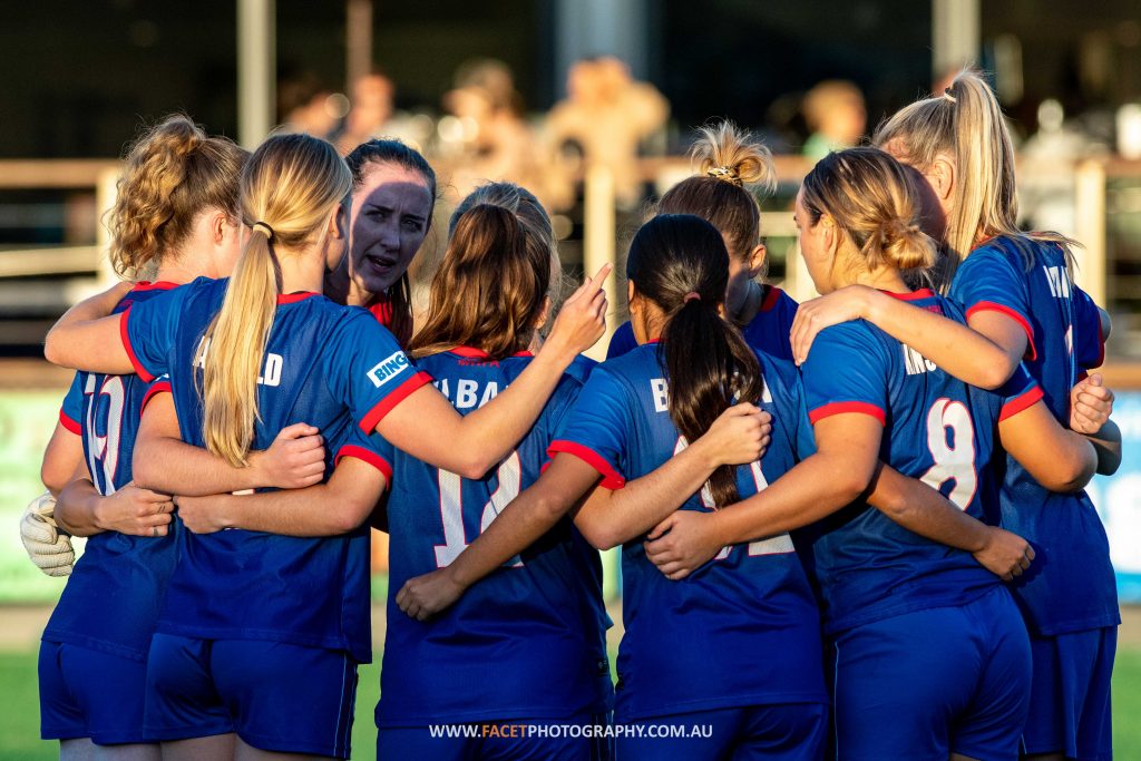 The Manly United Women's 1st grade team huddle before their 2023 NPL NSW Women's Round 6 game against Northern Tigers at Cromer Park. Photo credit: Jeremy Denham