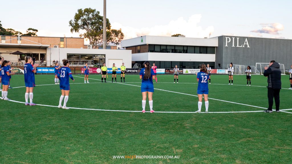 Manly United and Bulls FC Academy line up pre-game for a 30 second round of applause in support of match officials, prior to their 2023 Round 9 NPL NSW Women's game at Cromer Park. Photo credit: Jeremy Denham