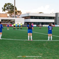 Manly United and Bulls FC Academy line up pre-game for a 30 second round of applause in support of match officials, prior to their 2023 Round 9 NPL NSW Women's game at Cromer Park. Photo credit: Jeremy Denham