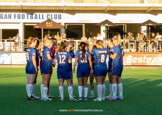 Manly United huddle before their 2023 NPL NSW Women's Round 6 game against Northern Tigers at Cromer Park. Photo credit: Jeremy Denham