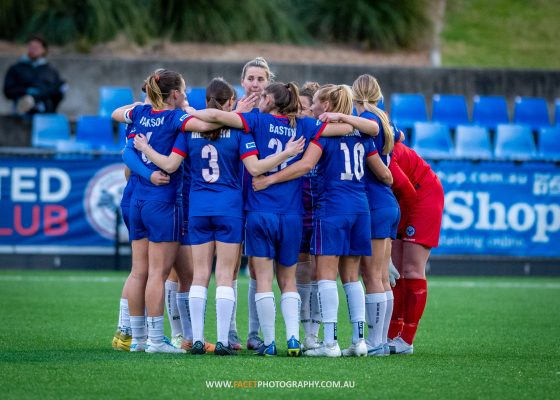 Manly United huddle before their 2023 NPL NSW Women's Round 23 game against NWS Spirit at Cromer Park. Photo credit: Jeremy Denham